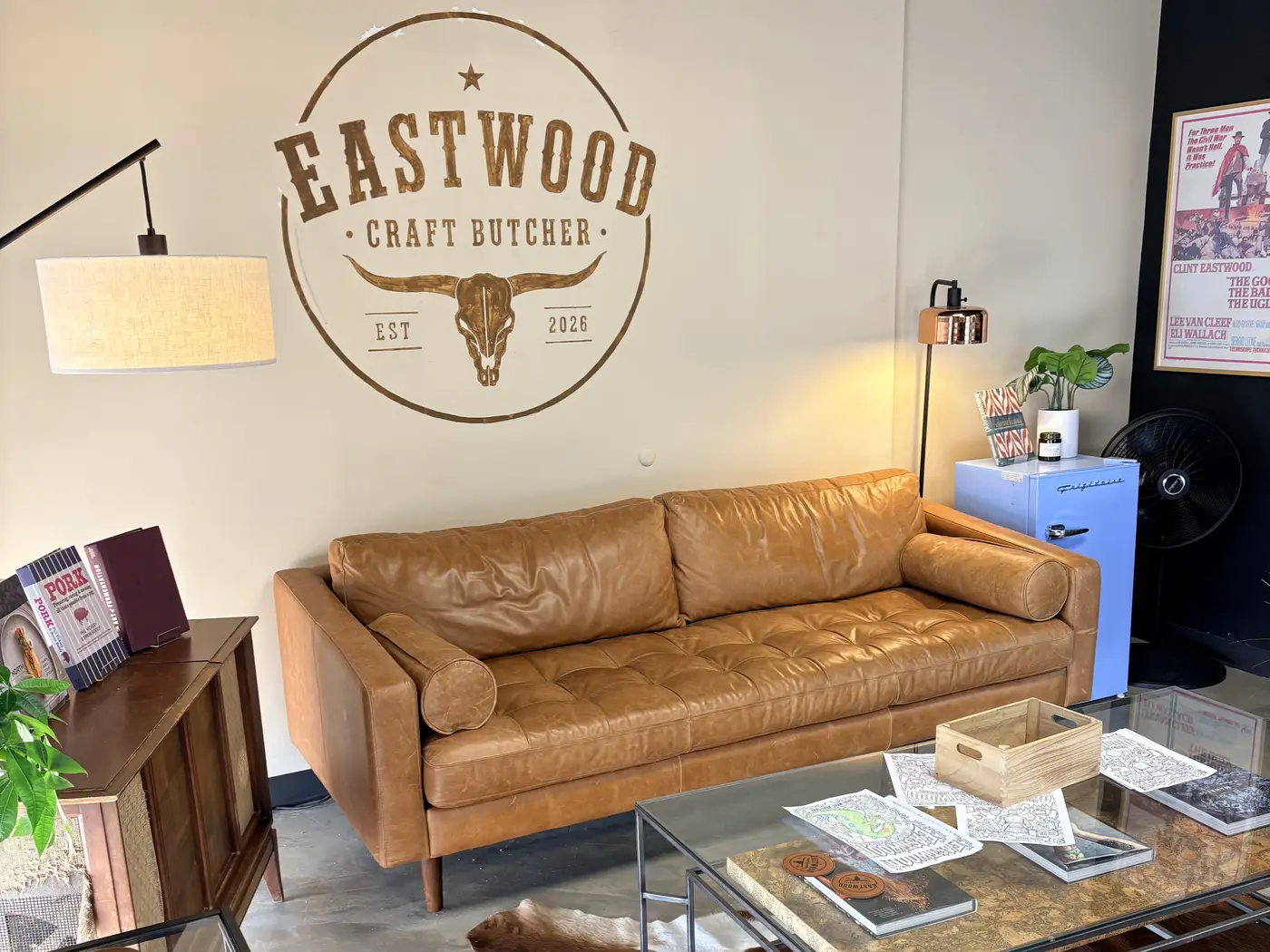 The shop's lounge with a leather couch, cowhide rug and the Eastwood logo on the wall