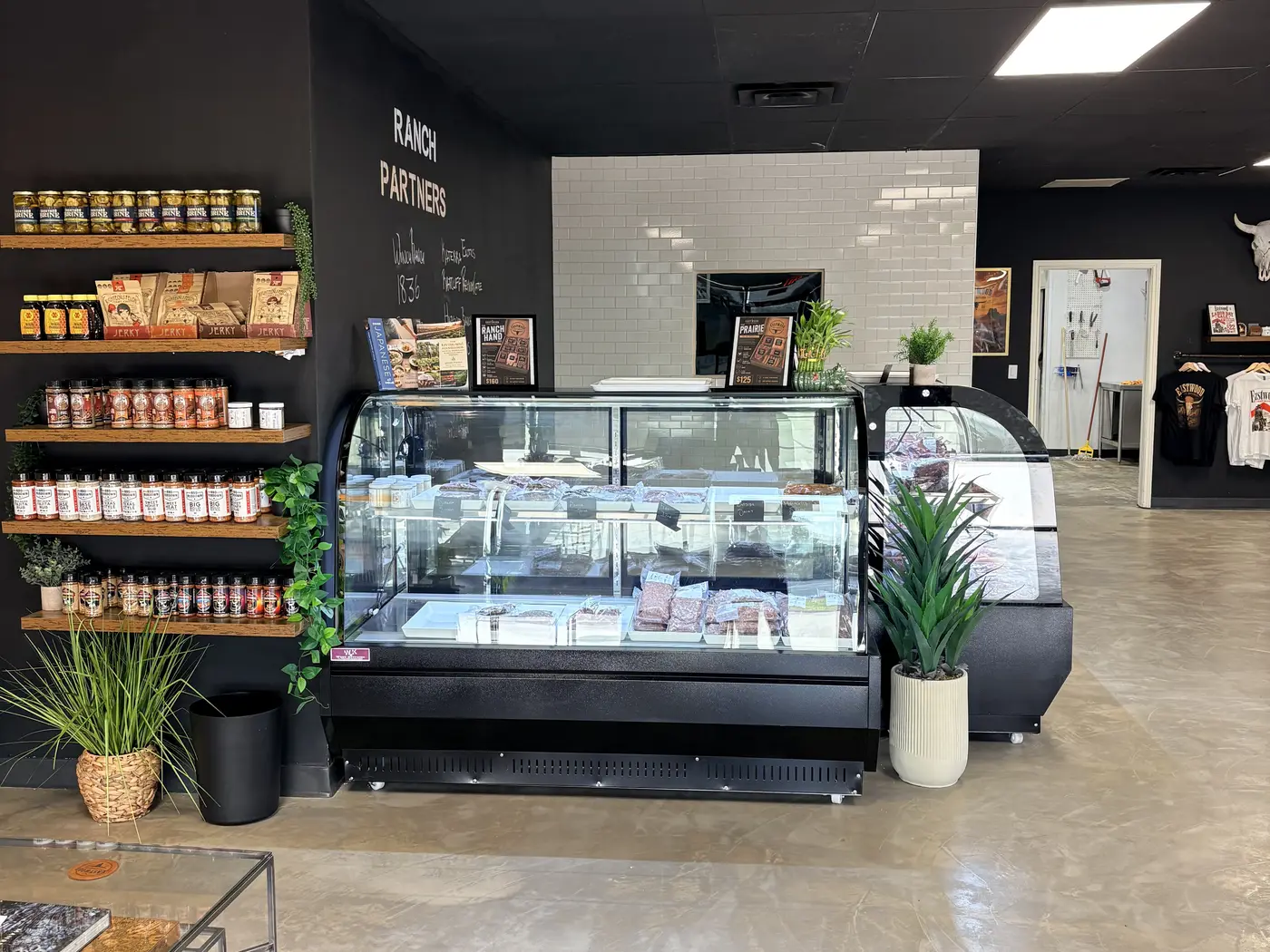 Shop floor with meat cases and shelves of sauces and rubs